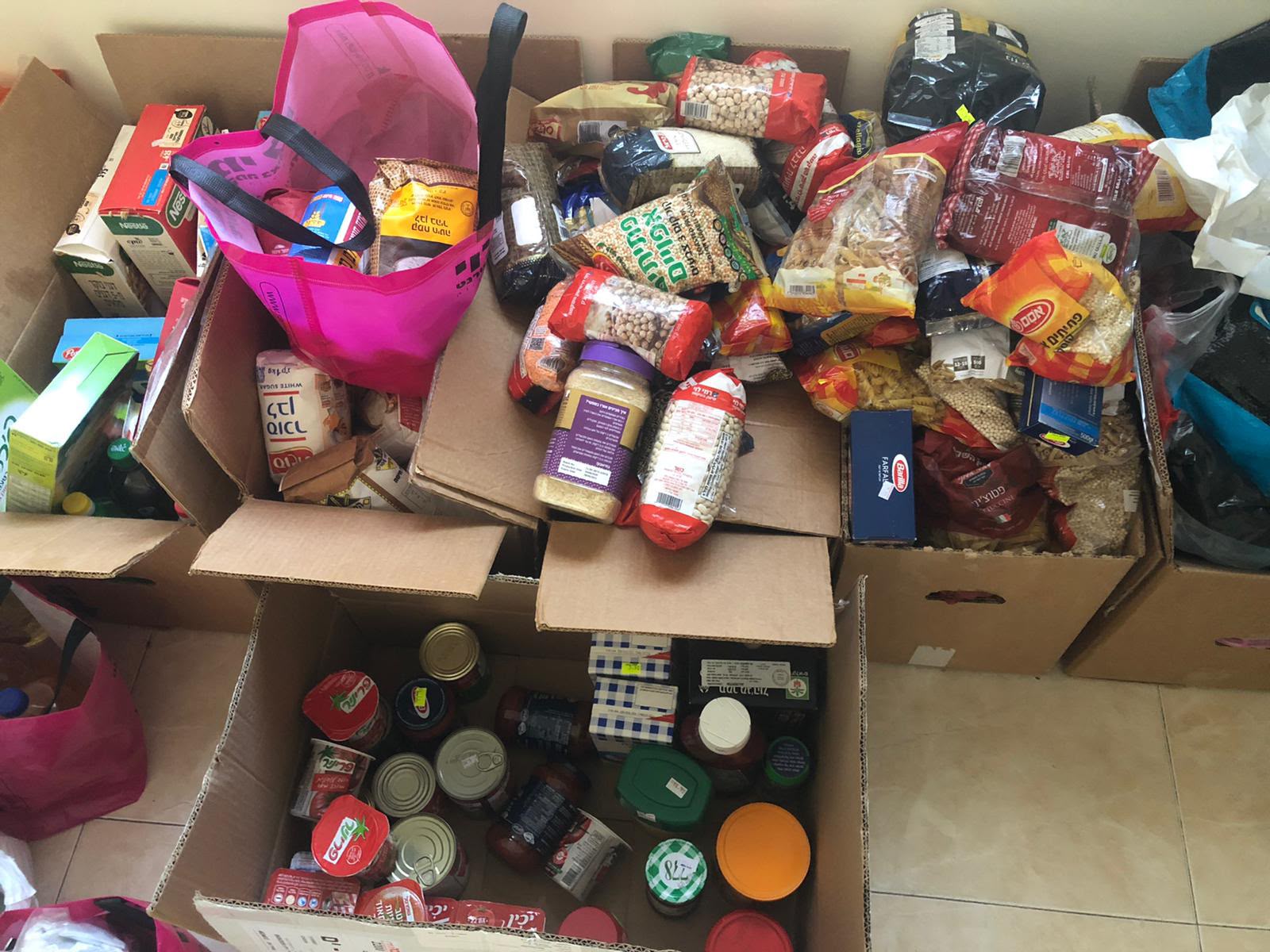 פסטה, קטניות, שימורים ומוצרים נוספים שחולקו לקרטוני קניות.